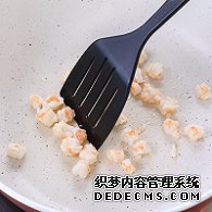 步驟圖:油熱后倒入蝦仁，用鍋鏟翻炒2分鐘至變色，盛出碗中備